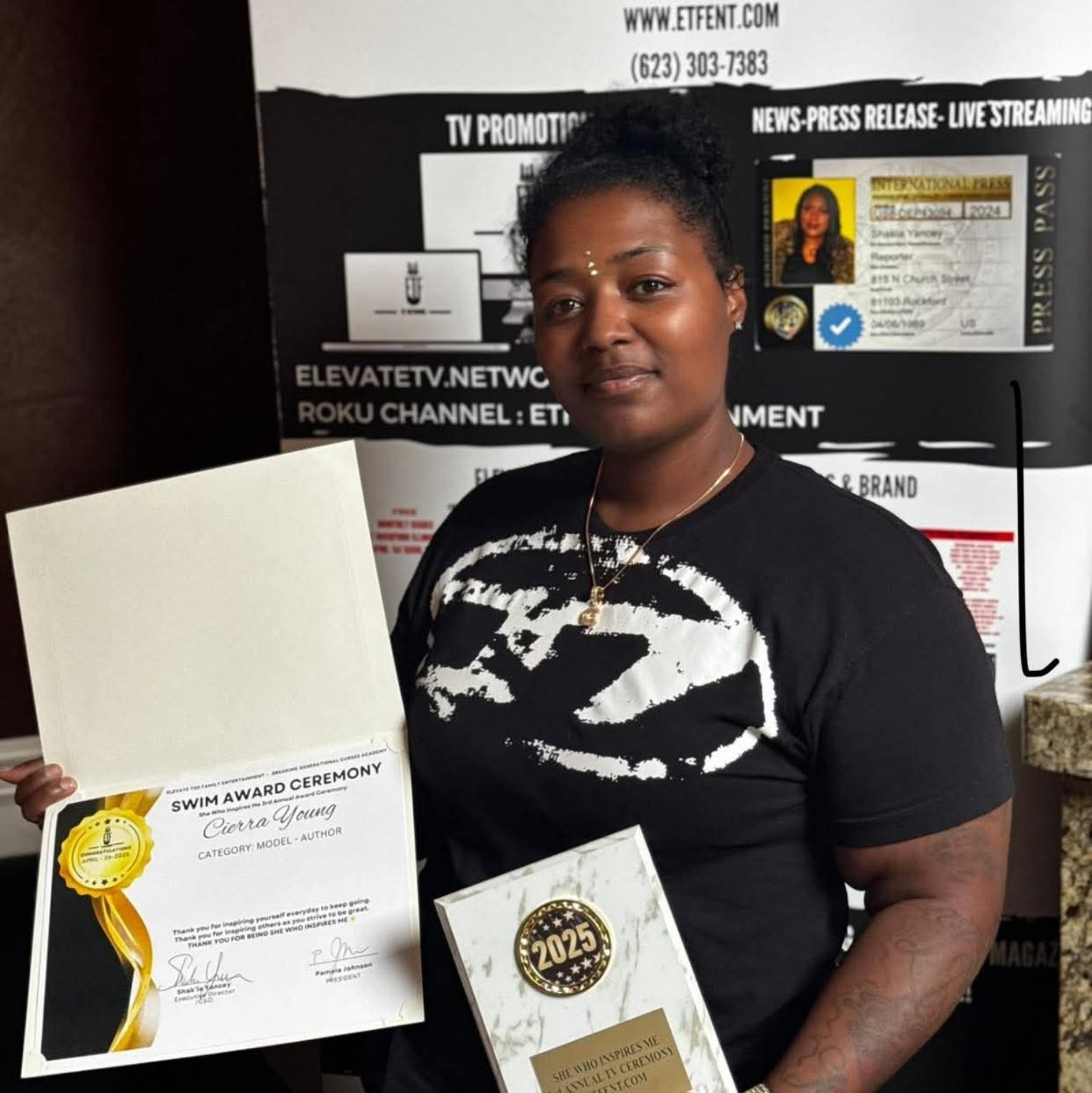 Cierra Young holding a She Who Inspires Me recognition certificate